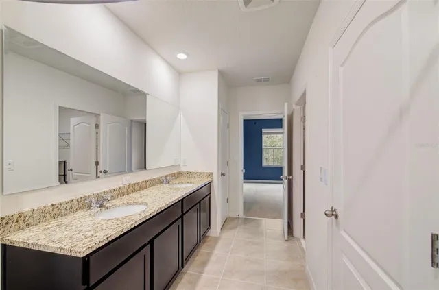 a bathroom with a granite countertop sink and a mirror