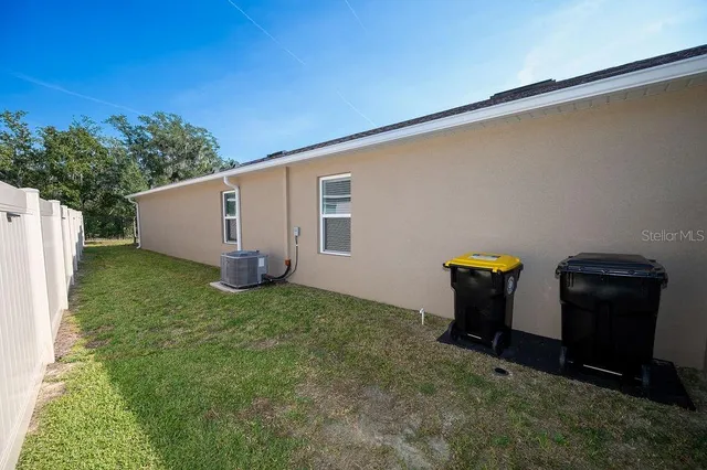 a backyard of a house with barbeque oven and wooden fence