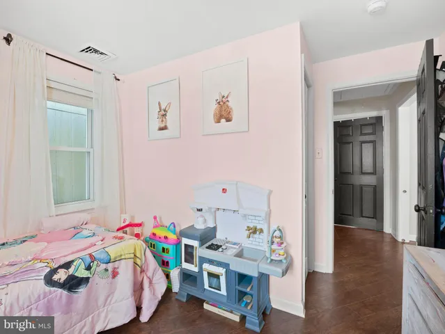 a bedroom with a bed and a wooden floor