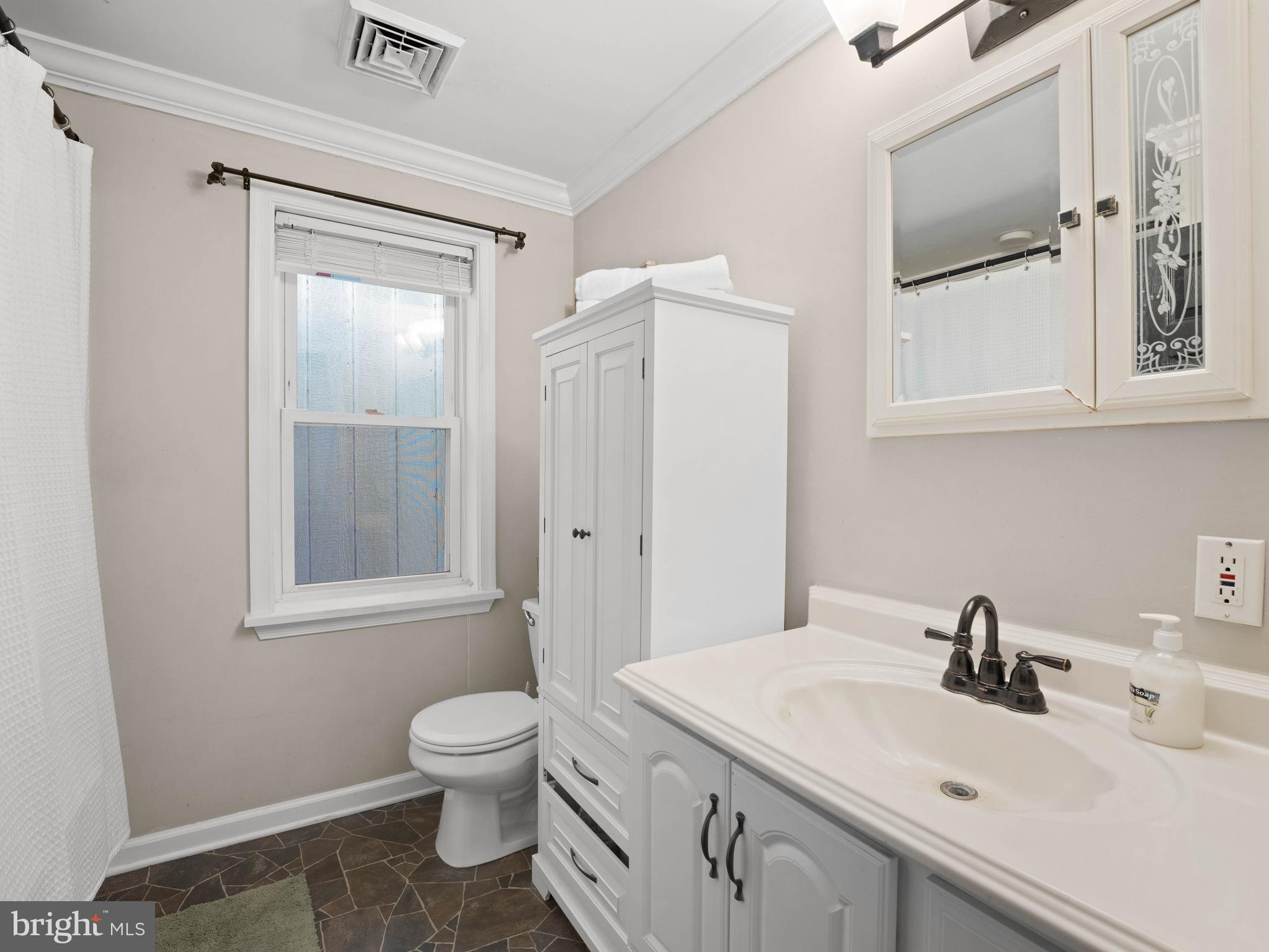 303 Garden Terrace Somers Point, NJ 08244 - Photo 17 of 38 a bathroom with a toilet a sink and mirror
