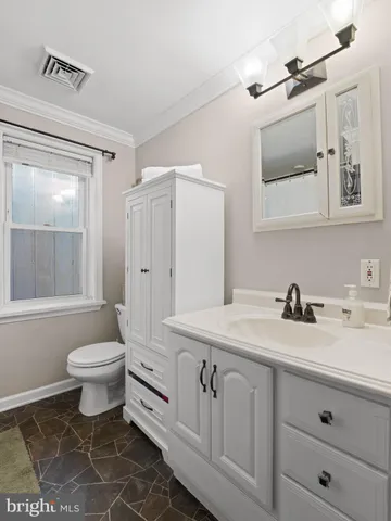 a bathroom with a granite countertop sink mirror vanity and toilet