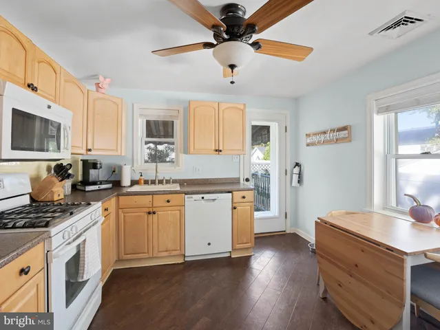 a kitchen with granite countertop a sink cabinets stainless steel appliances and a window