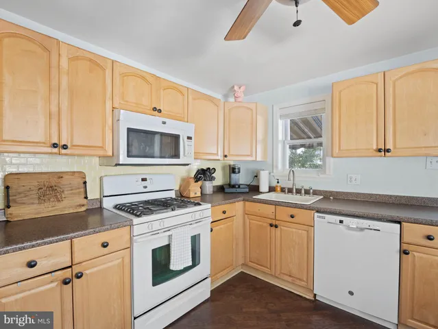 a kitchen with granite countertop white cabinets and white appliances