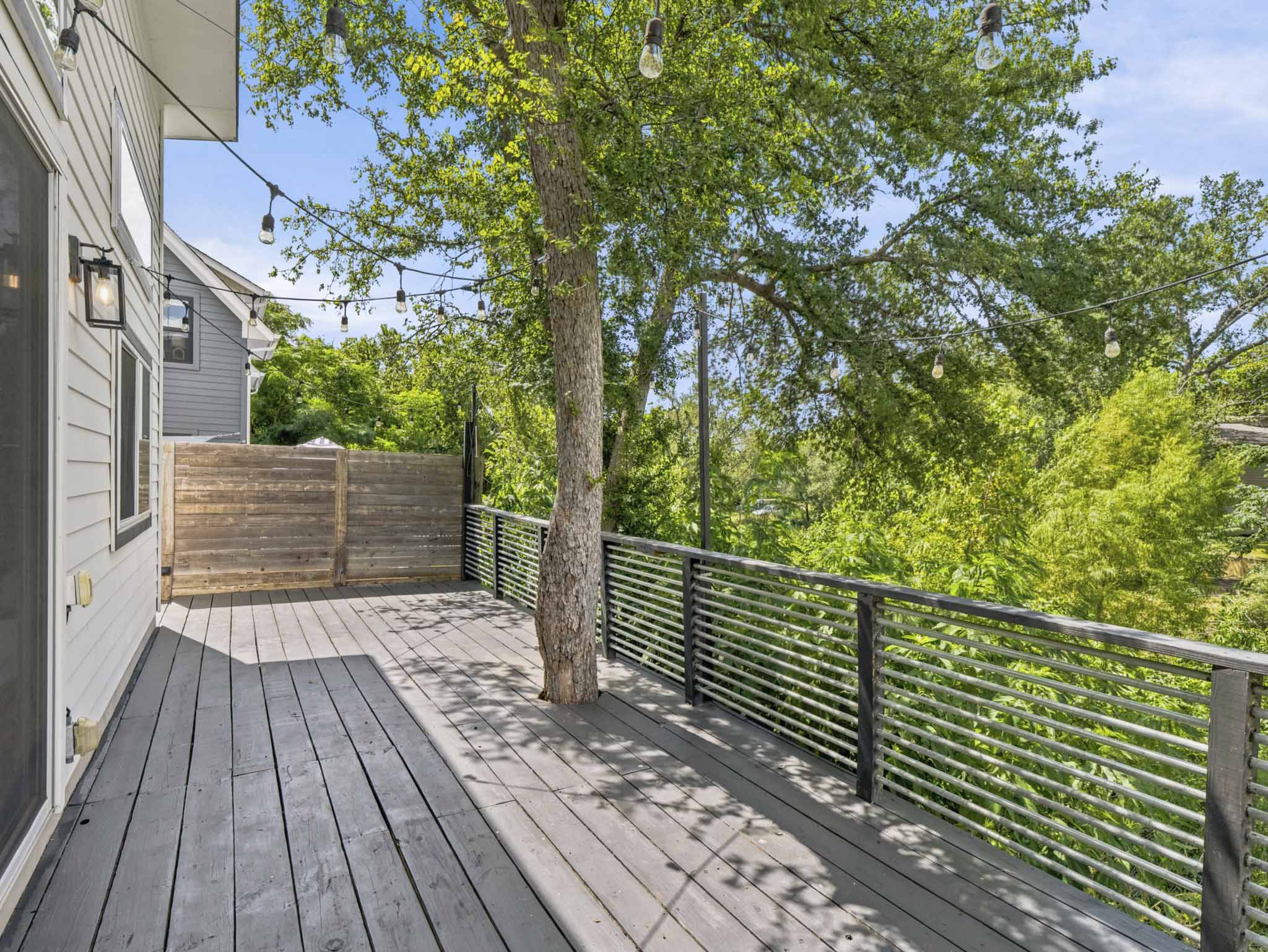 5005 Lott Avenue, Unit 2 Austin, TX 78721 - Photo 16 of 25 An inviting outdoor deck provides an ideal setting for relaxation amidst lush greenery.