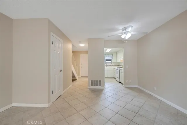 a view of a hallway with wooden floor and a kitchen