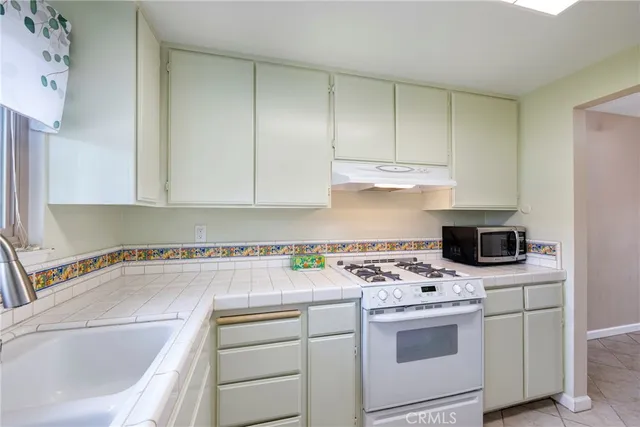 a kitchen with a sink stove and cabinets