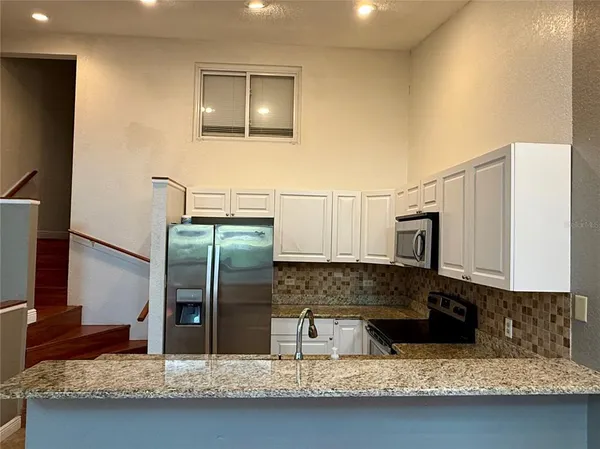 a view of kitchen with stainless steel appliances granite countertop cabinets and a sink