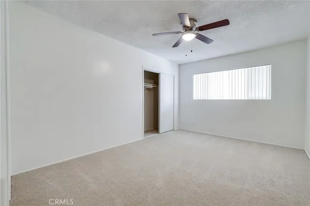 an empty room with windows and fan