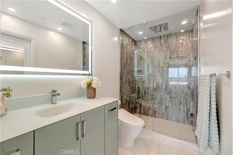 a bathroom with a shower sink vanity mirror and toilet