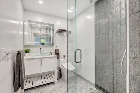 a bathroom with a sink a toilet and shower