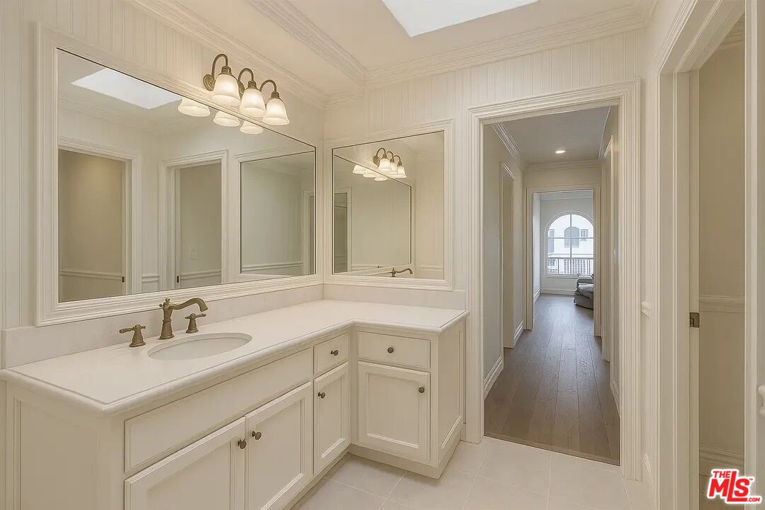 21620 Burbank Boulevard, Unit 9 Woodland Hills, CA 91367 - Photo 11 of 14 a bathroom with a sink a light fixture a vanity and a mirror