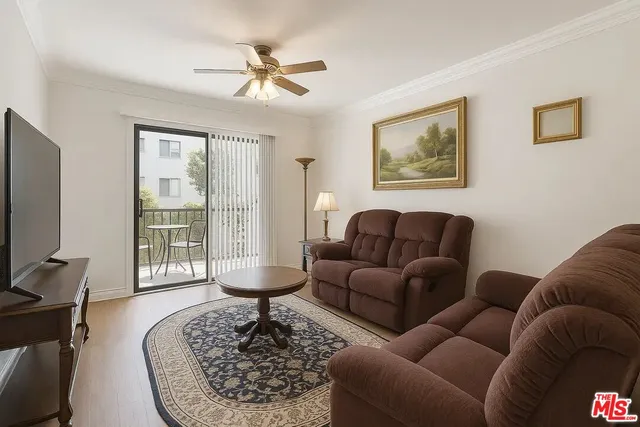 a living room with furniture a couch and a flat screen tv with wooden floor
