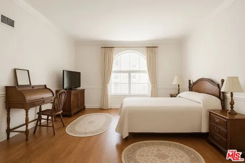 a bedroom with a bed a chair and a window