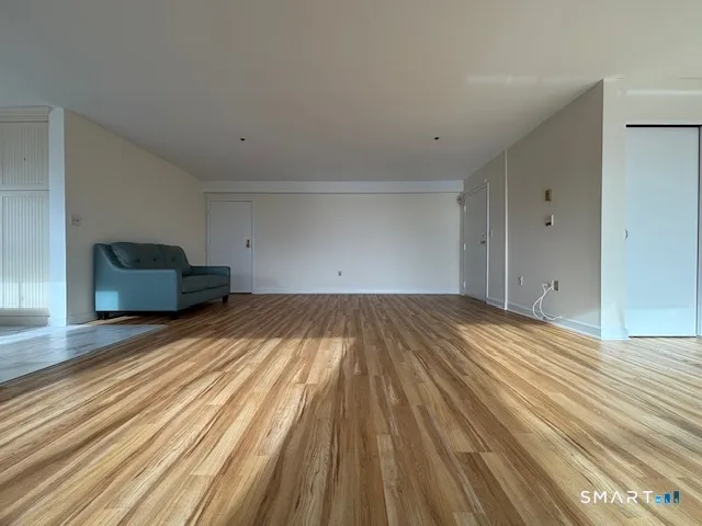 a view of empty room with wooden floor