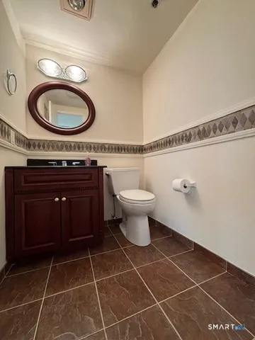 a bathroom with a toilet a sink and mirror