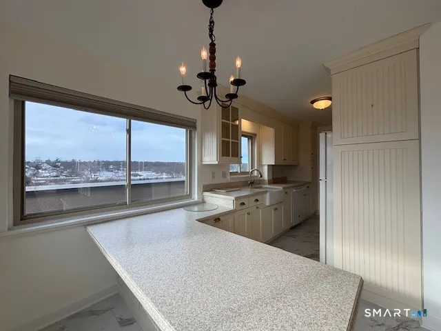 a large kitchen with kitchen island a large counter space a sink appliances and cabinets