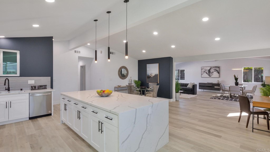 a large kitchen with kitchen island a sink appliances and a dining table