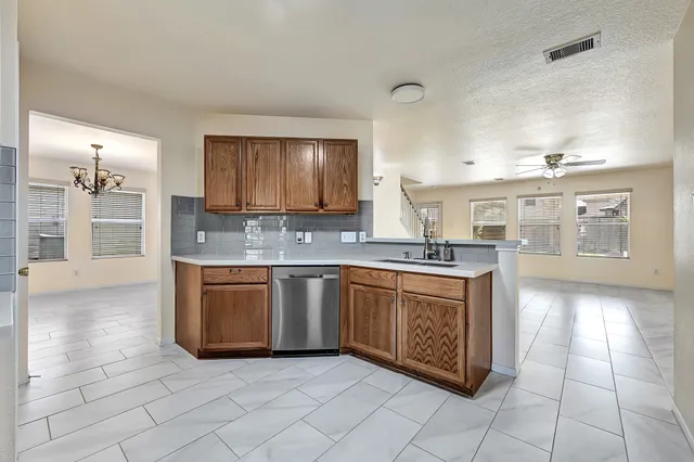 a large kitchen with granite countertop a sink and cabinets