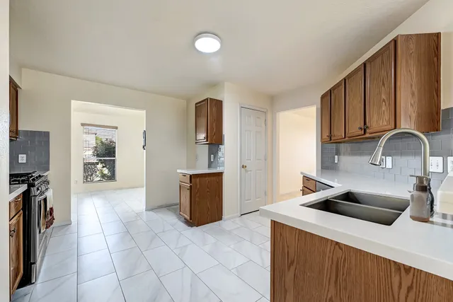 a kitchen with a sink a stove and cabinets