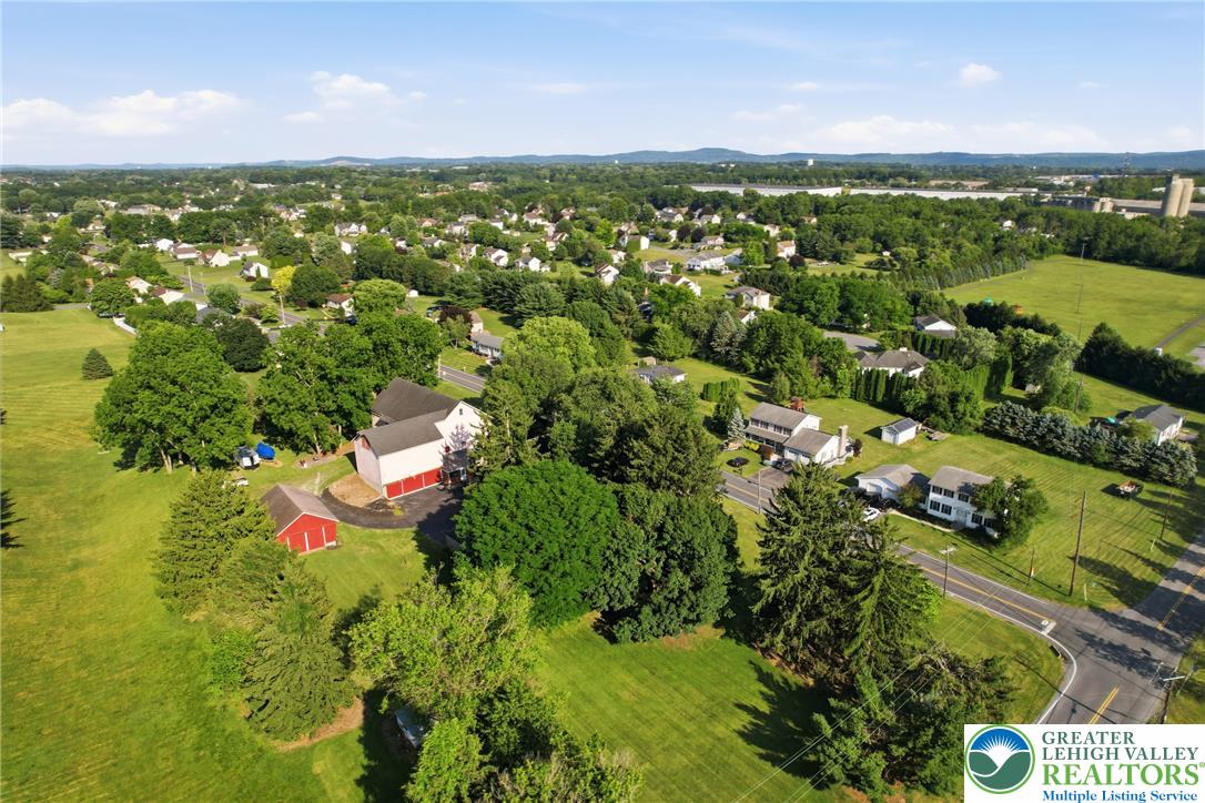 4682 Steuben Road Bethlehem, PA 18020 - Photo 70 of 79 An aerial perspective reveals a serene residential neighborhood embraced by green fields and distant hills.
