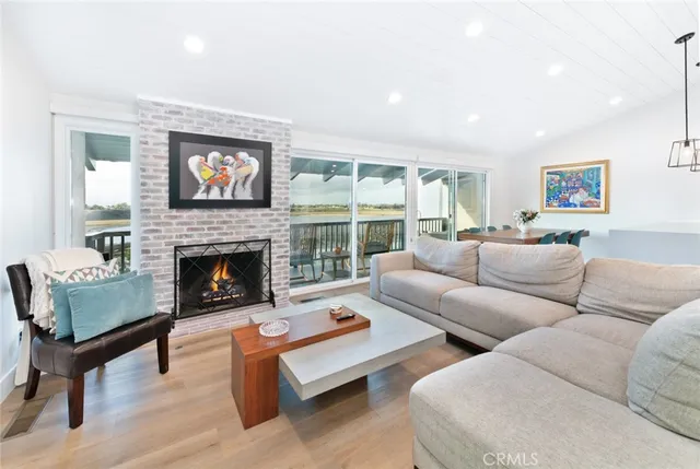 a living room with furniture a fireplace and a floor to ceiling window