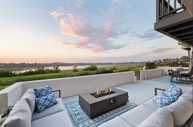 an outdoor living room with furniture and a garden