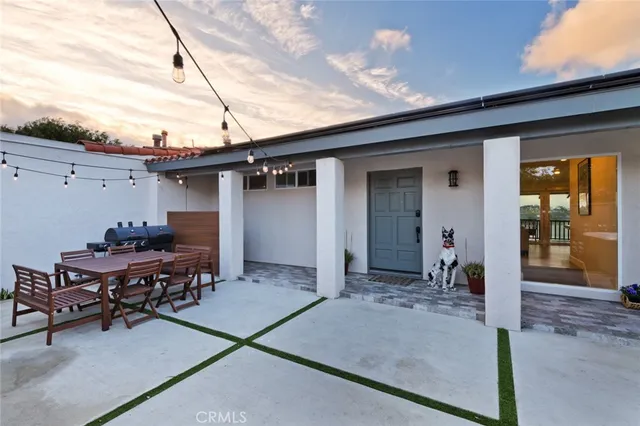 a backyard of a house with table and chairs