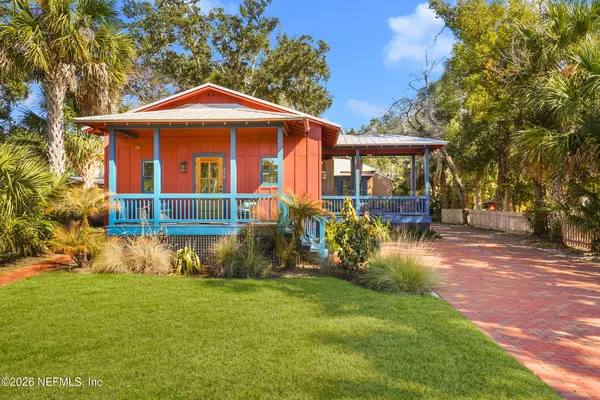 a living room with a couch and a dining table with wooden floor