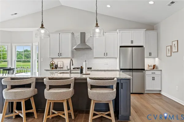 a kitchen with stainless steel appliances kitchen island a table and chairs in it
