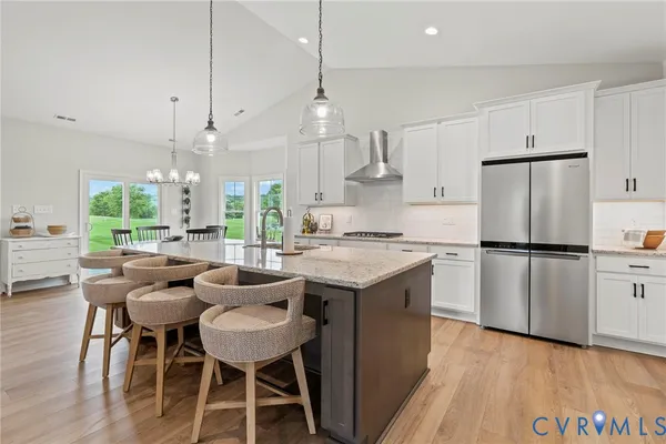 a kitchen with refrigerator a sink and chairs