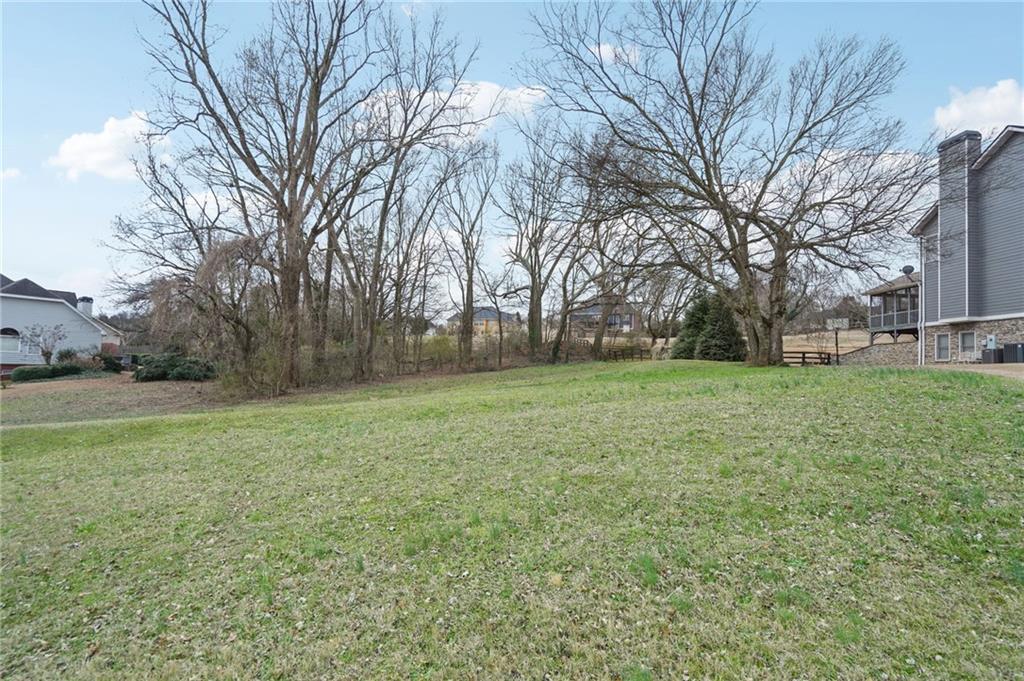 693 Reece Drive Hoschton, GA 30548 - Photo 4 of 16 a view of a field of grass and trees