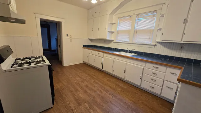 a kitchen with stainless steel appliances a sink stove and cabinets