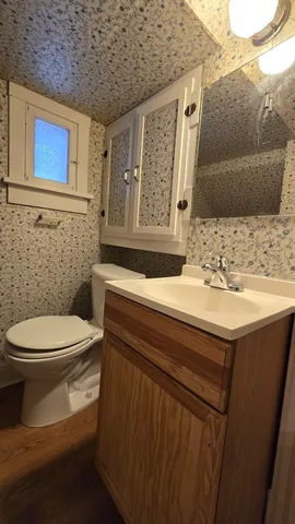 an empty room with chandelier fan and windows