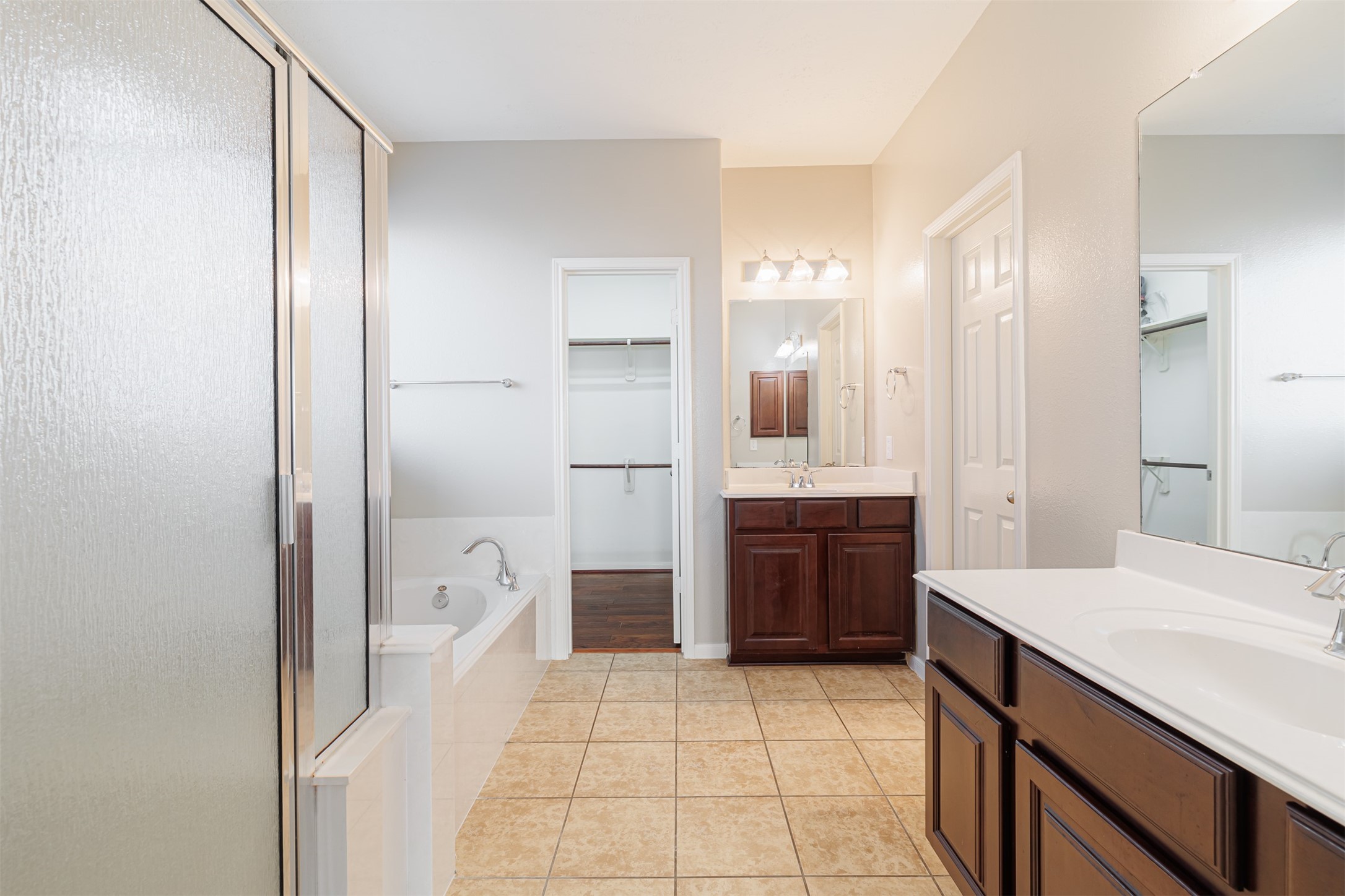 8322 Encinitas Cove Drive Tomball, TX 77375 - Photo 11 of 24 a large bathroom with a glass door shower a sink and a mirror