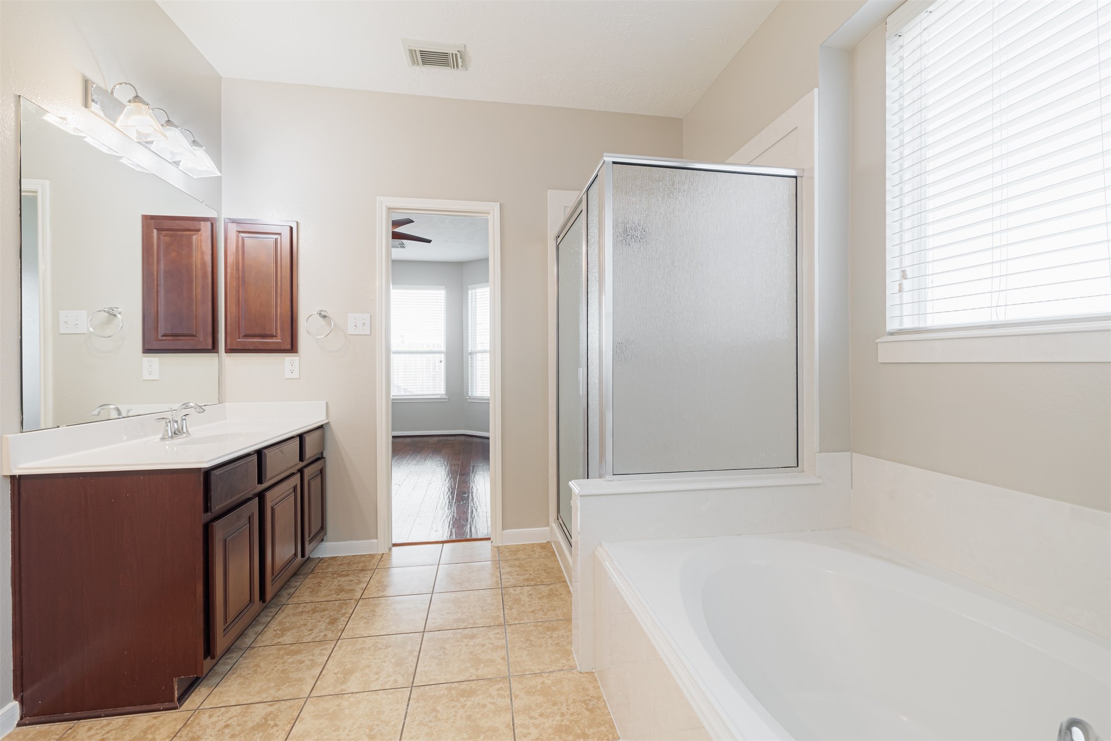 8322 Encinitas Cove Drive Tomball, TX 77375 - Photo 13 of 24 a bathroom with a tub sink and mirror