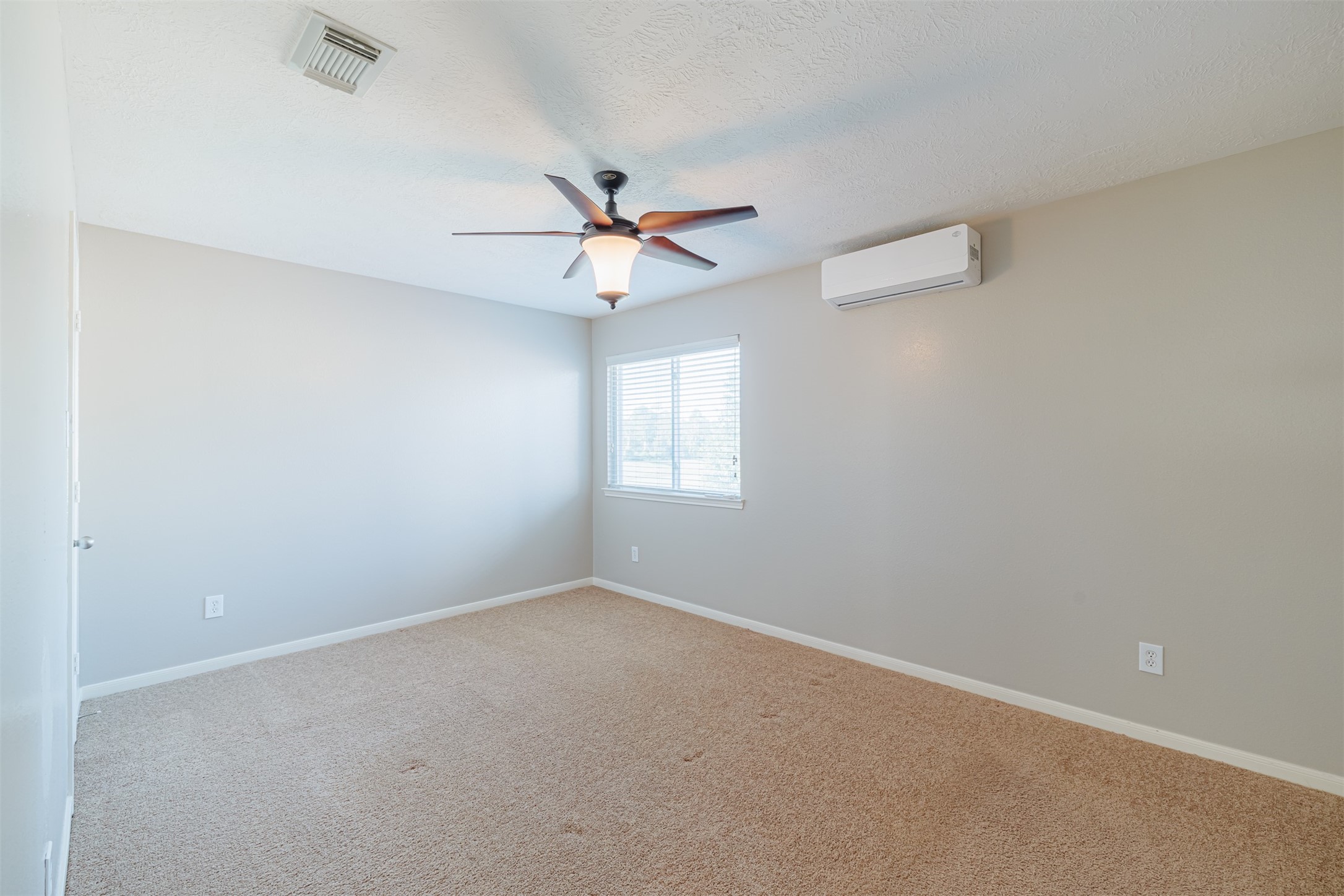 8322 Encinitas Cove Drive Tomball, TX 77375 - Photo 23 of 24 an empty room with a window and a fan