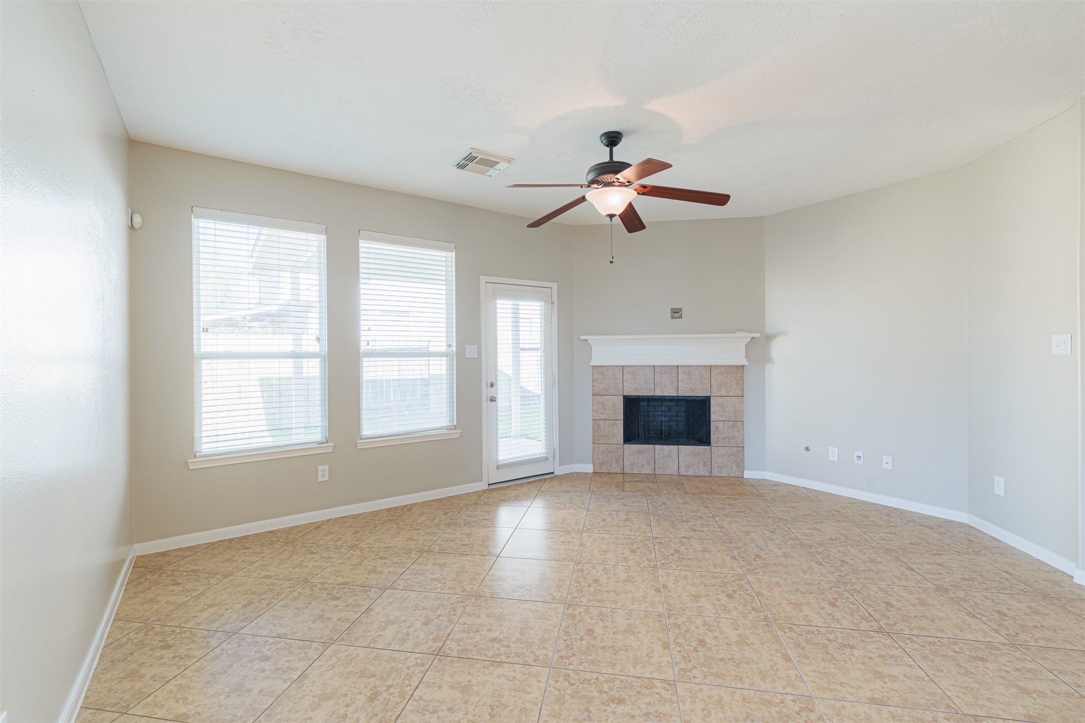 8322 Encinitas Cove Drive Tomball, TX 77375 - Photo 7 of 24 a view of an empty room with a fireplace and a window