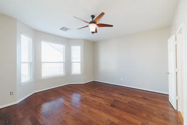 wooden floor in an empty room with a window