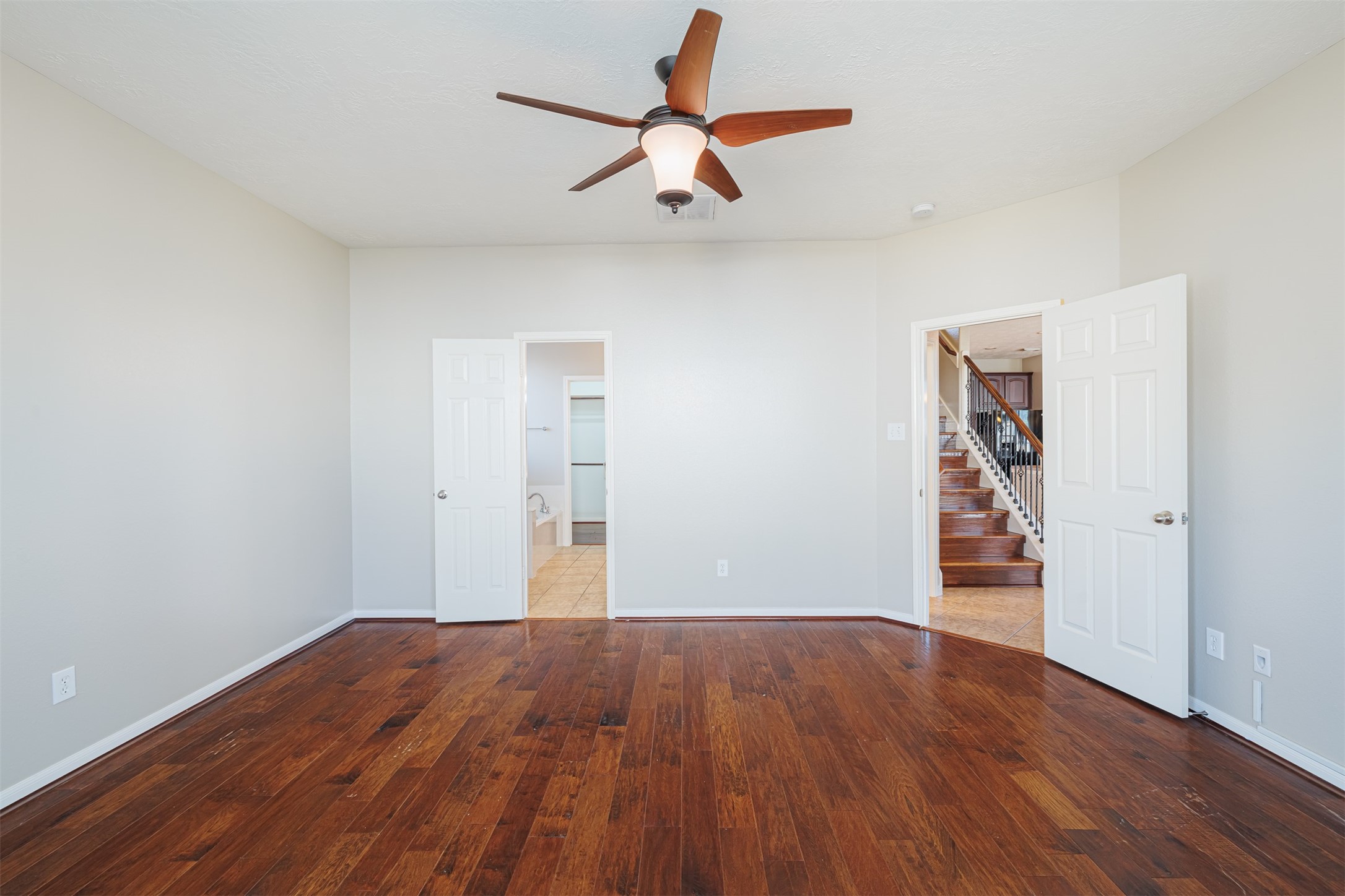 8322 Encinitas Cove Drive Tomball, TX 77375 - Photo 10 of 24 an empty room with wooden floor chandelier fan and windows
