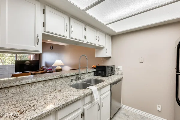 a kitchen with granite countertop a sink and cabinets