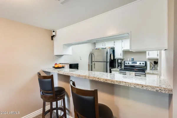a kitchen with stainless steel appliances granite countertop a sink refrigerator and cabinets