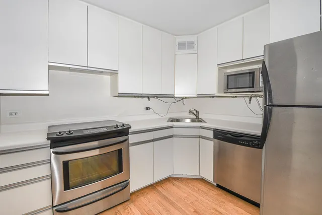 a kitchen with granite countertop a refrigerator stove and sink