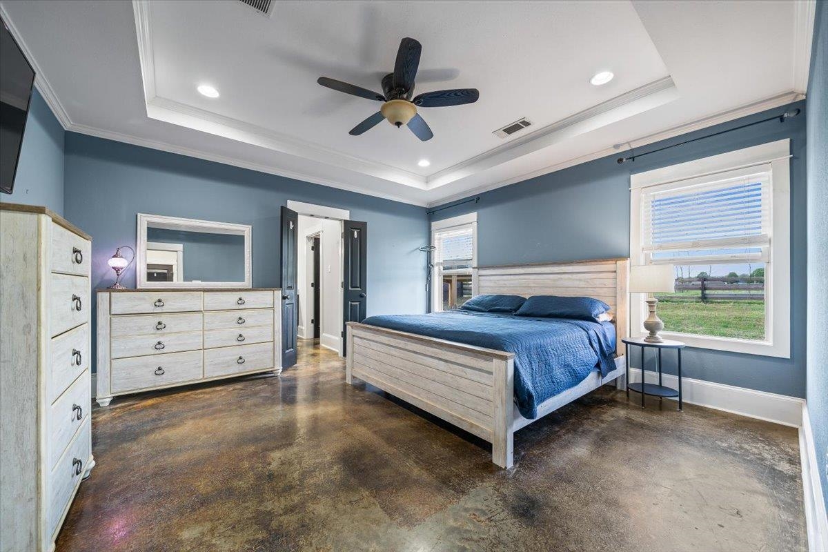206 Deen Road Brighton, TN 38011 - Photo 19 of 35 Spacious bedroom featuring stained concrete flooring, a tray ceiling with recessed lighting and a ceiling fan, and multiple windows offering natural light