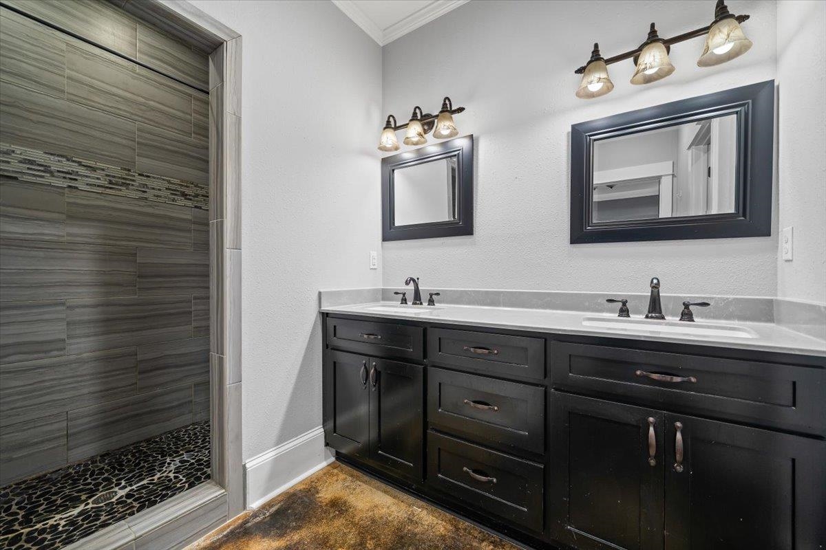 206 Deen Road Brighton, TN 38011 - Photo 20 of 35 Double vanity with integrated sinks, dark wood cabinetry, and framed mirrors