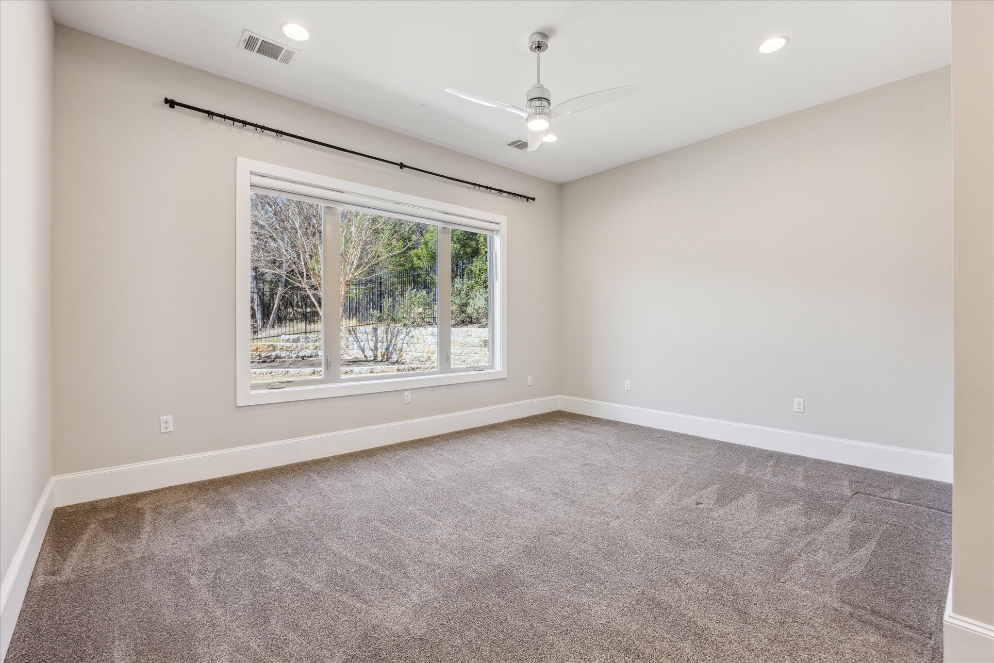 2604 Arion Circle Austin, TX 78730 - Photo 16 of 23 en empty room with windows and chandelier fan