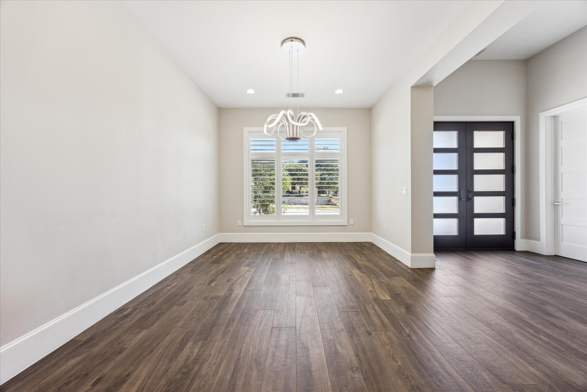 2604 Arion Circle Austin, TX 78730 - Photo 3 of 23 an empty room with wooden floor exposed radiator and windows