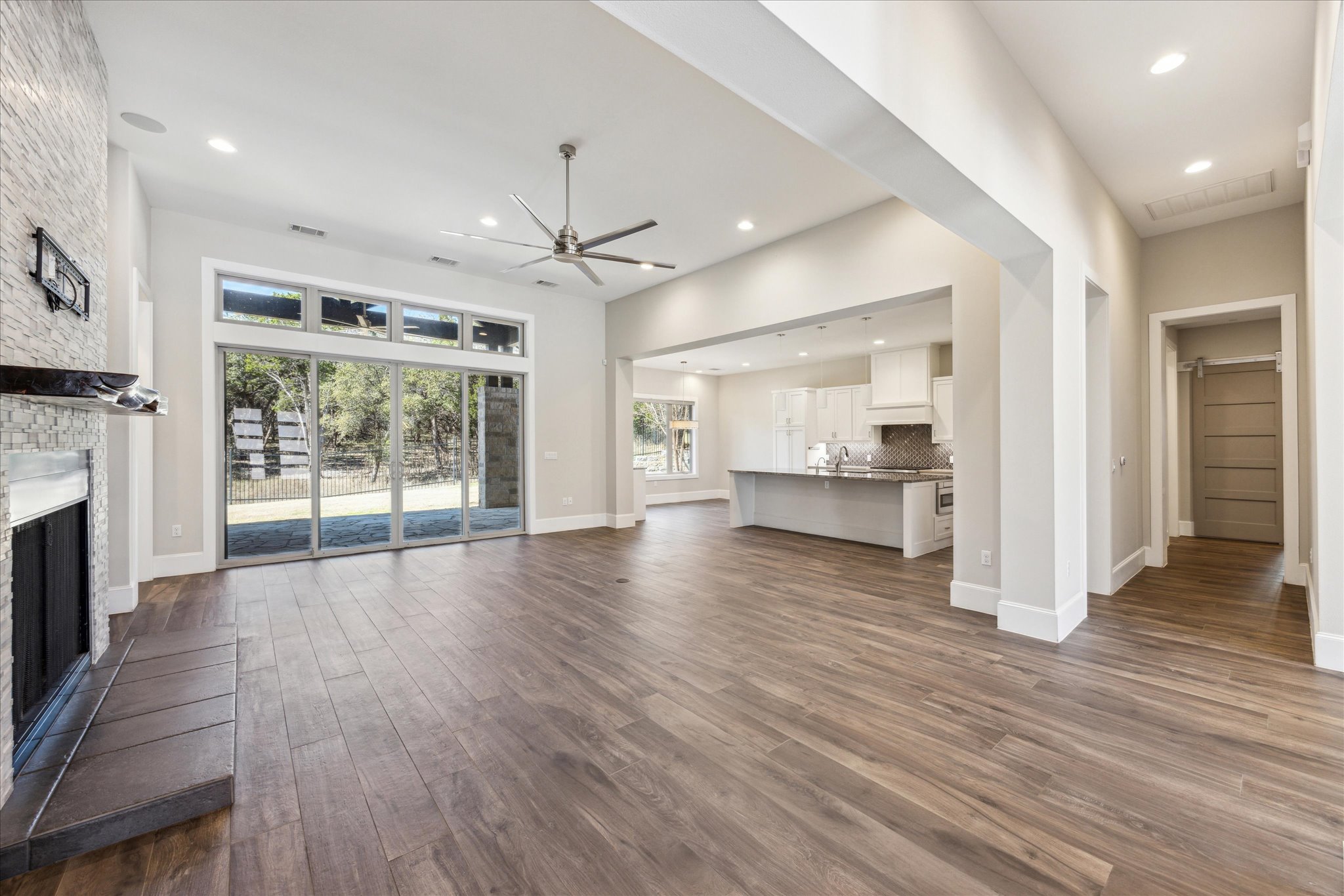 2604 Arion Circle Austin, TX 78730 - Photo 4 of 23 an empty room with wooden floor fireplace and windows