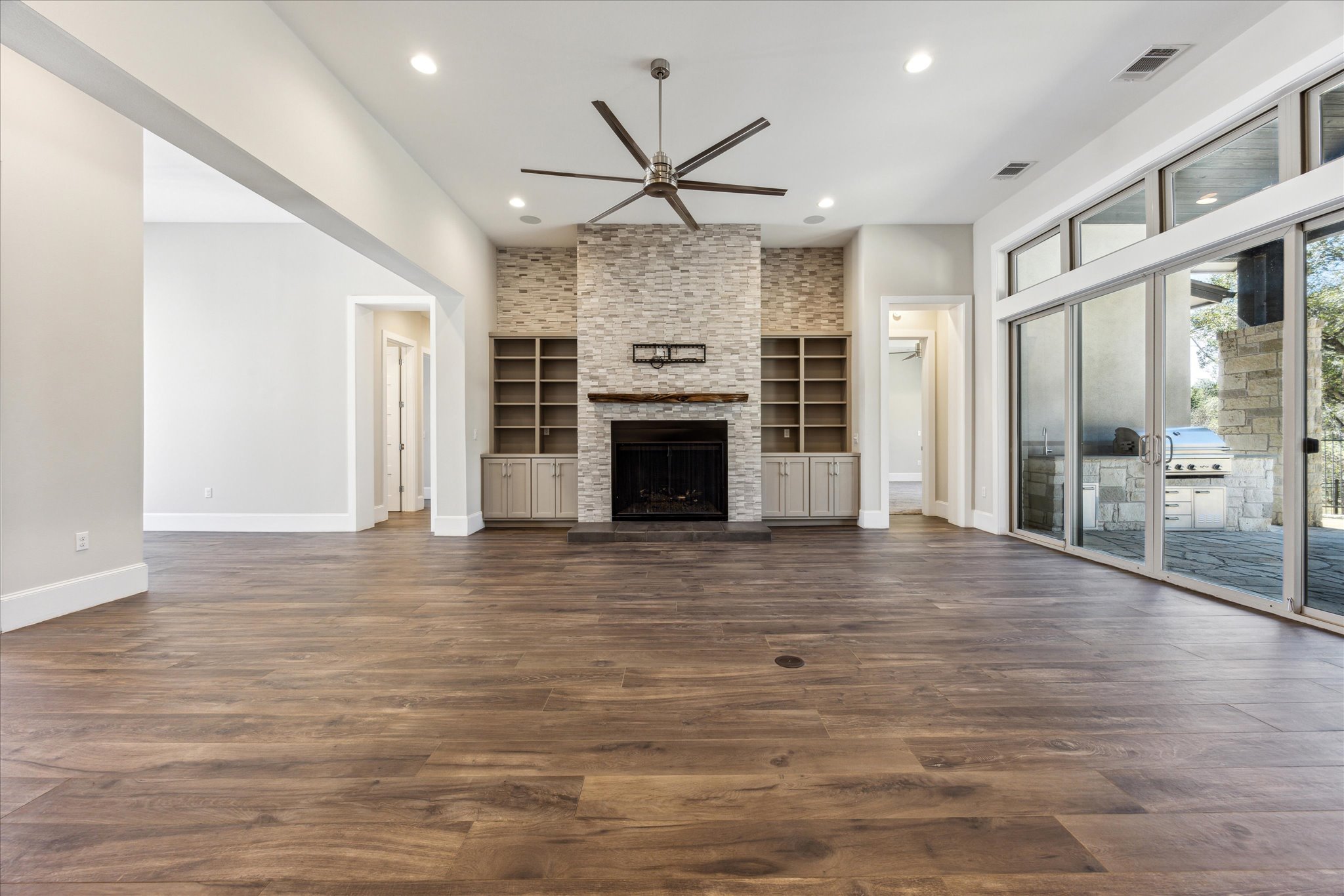 2604 Arion Circle Austin, TX 78730 - Photo 6 of 23 a view of a livingroom with a fireplace wooden floor and a ceiling fan