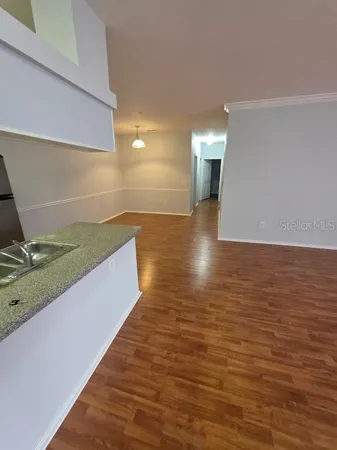 a kitchen with kitchen island wooden floors appliances and cabinets