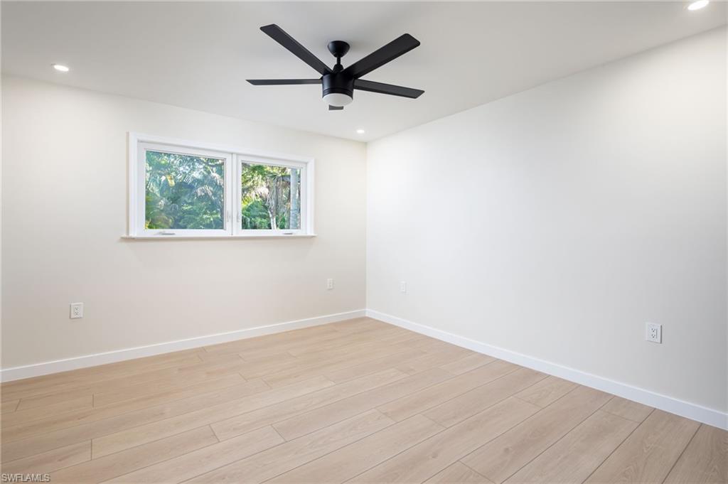 2424 Harbor Road Naples, FL 34104 - Photo 13 of 26 an empty room with wooden floor and windows